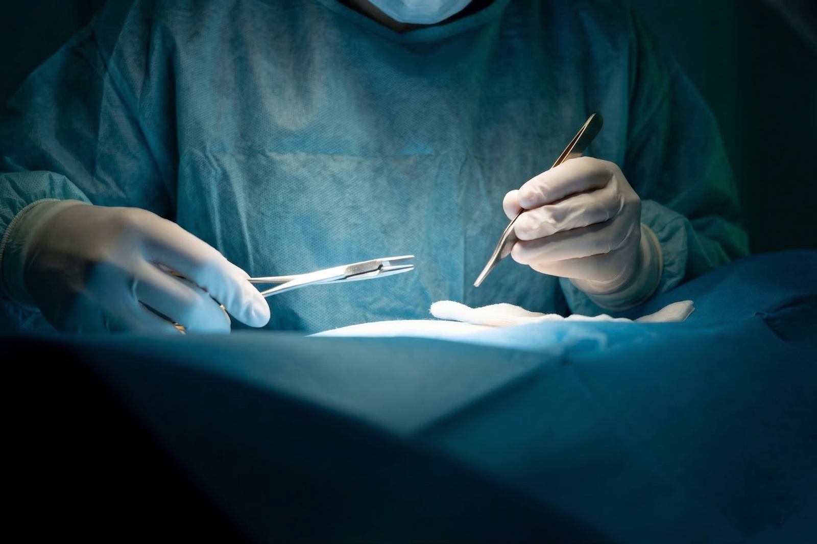 Surgeon holding surgical instruments during procedure
